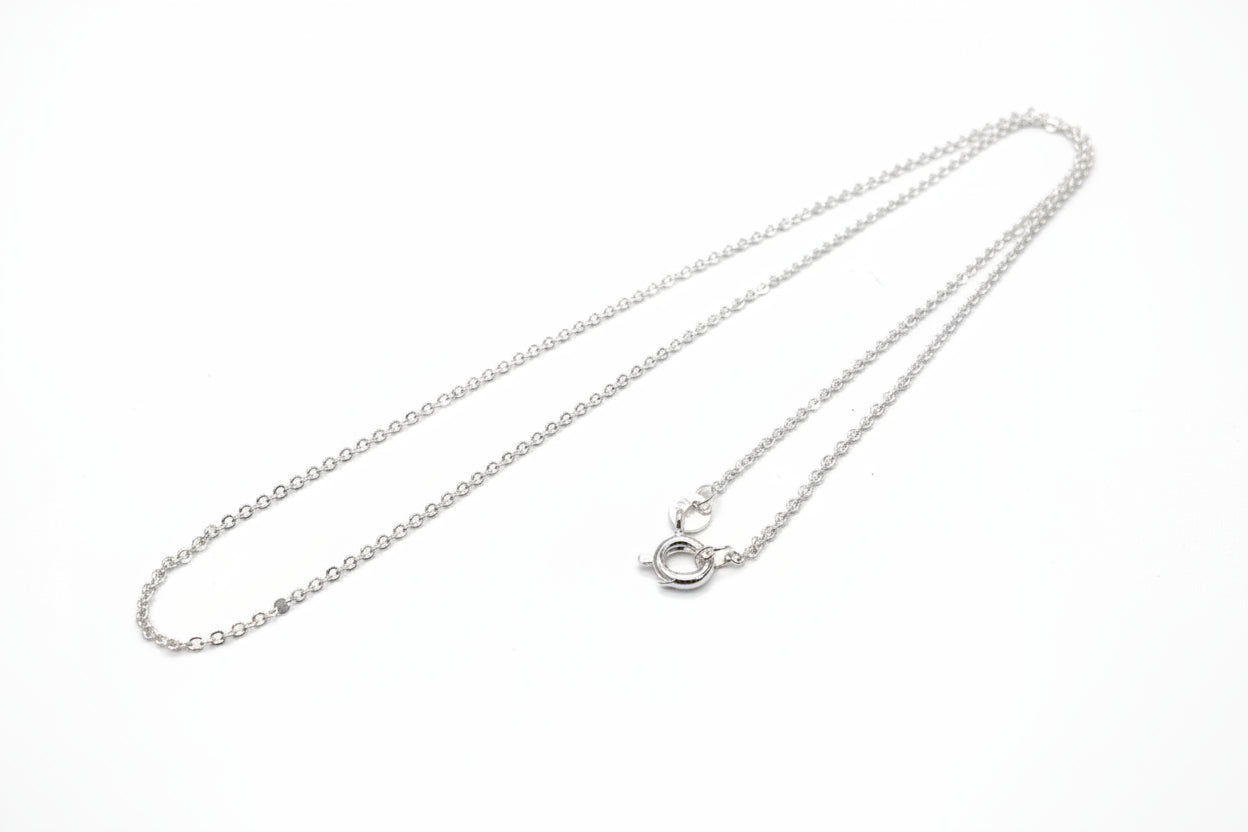 Silver necklace on a light gray background