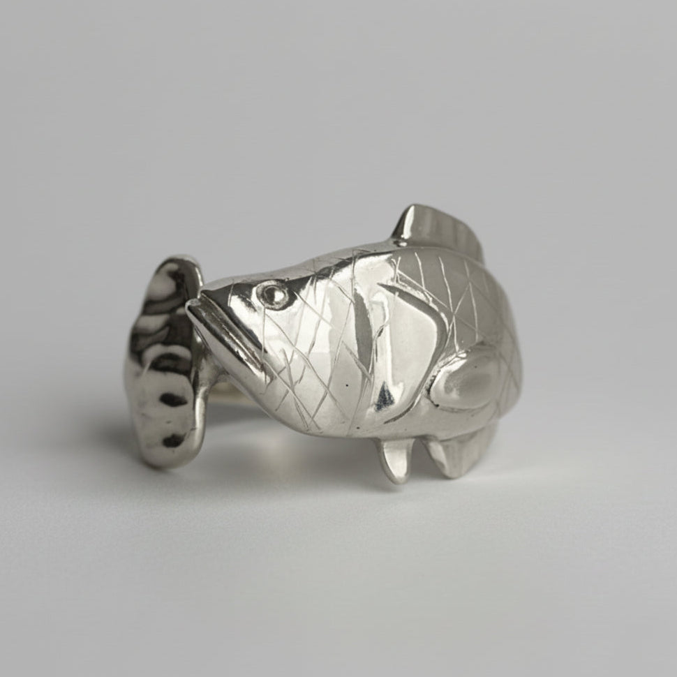 Silver Snakehead fish-shaped object on a light gray background