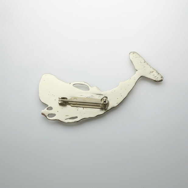 Silver whale-shaped object on a light gray background
