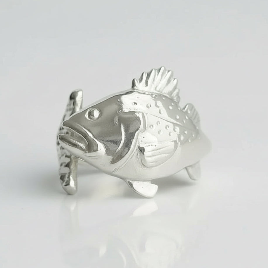 Silver fish-shaped object on a light gray background