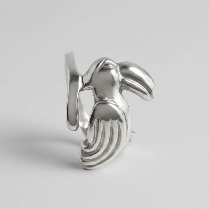 Silver toucan-shaped earring on a light gray background
