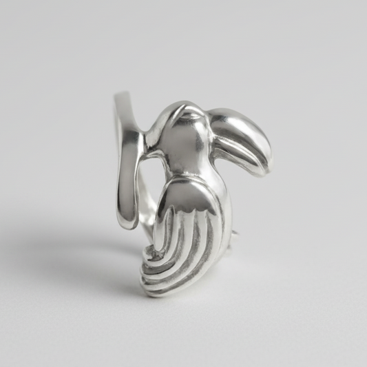 Silver toucan-shaped earring on a light gray background
