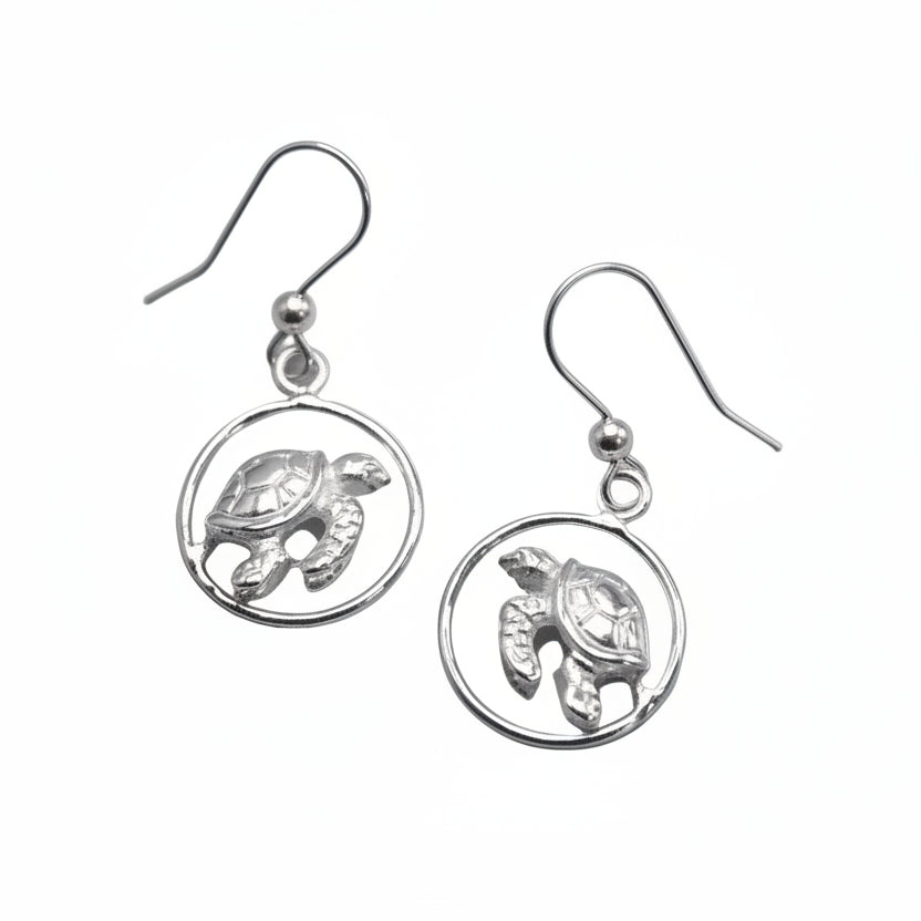 Pair of silver turtle earrings on a light gray background