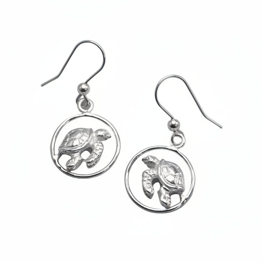 Pair of silver turtle earrings on a light gray background