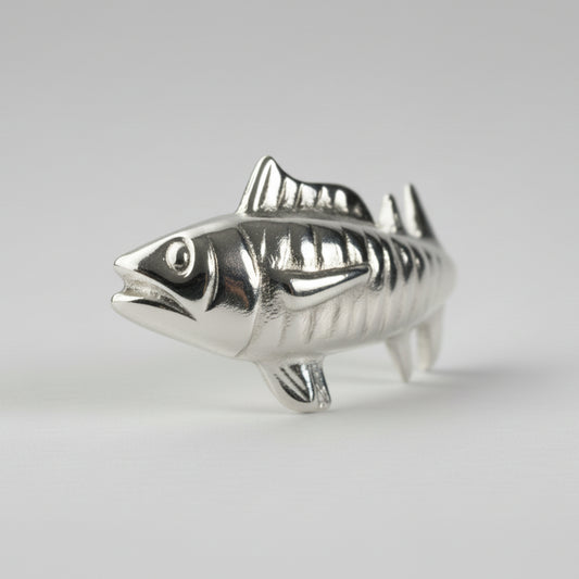 Silver fish-shaped object on a white background