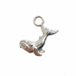 Silver whale charm on a white background