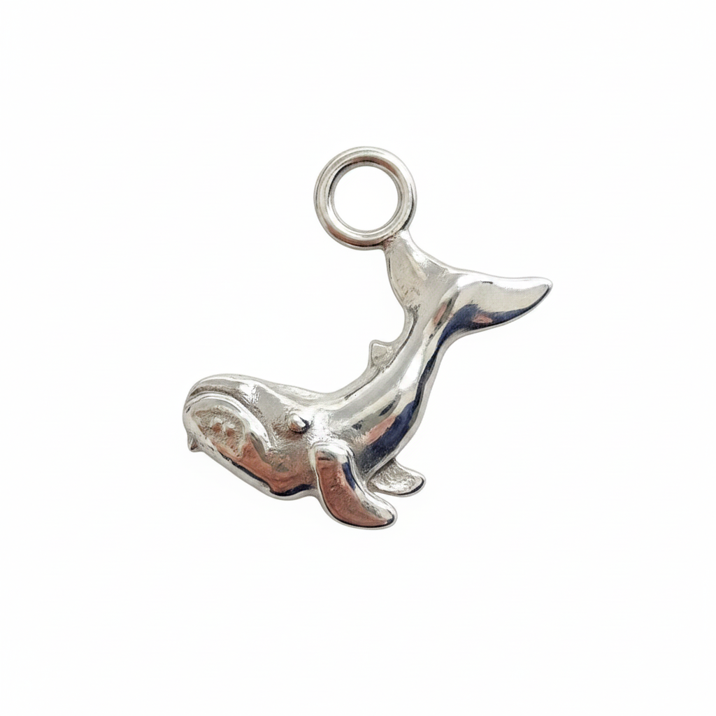 Silver whale charm on a white background