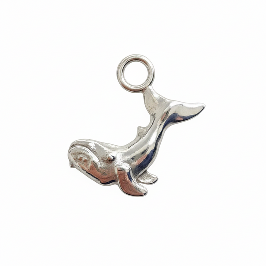 Silver whale charm on a white background